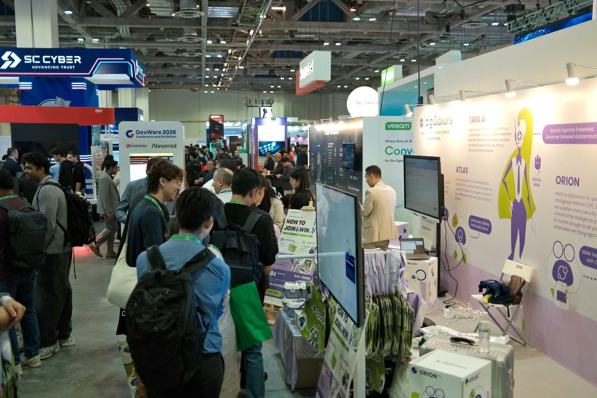 Visitors crowd around Booth D-02 at GovWare 2026, many carrying digiDations tote bags.
