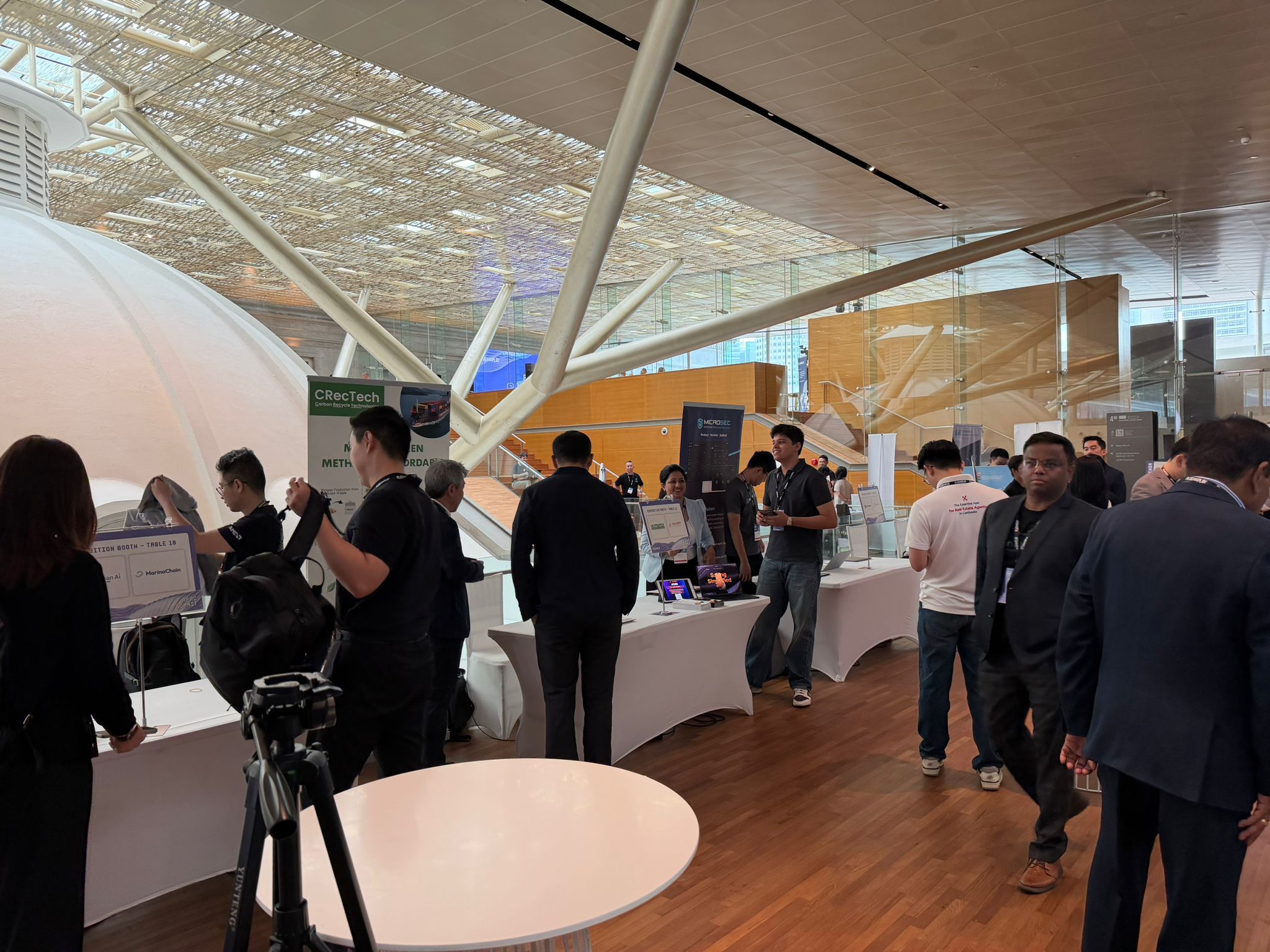 Exhibition area with attendees and booths at Plug and Play APAC 2025